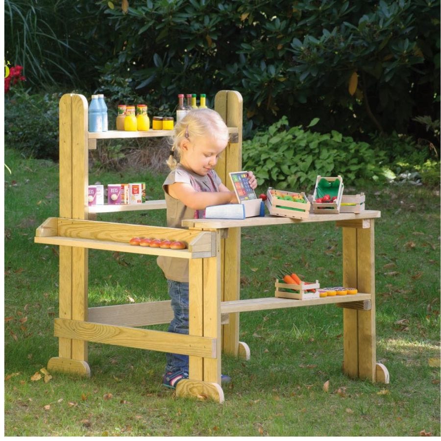 Kleines Mädchen spielt an Erzi Outdoor Kaufladen im Garten mit Spiellebensmitteln