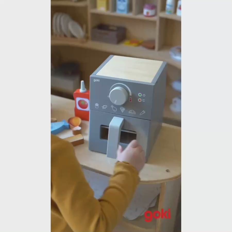 goki Airfryer aus Holz im Einsatz: Spiellebensmittel mit der Holzzange in die Schublade legen.
