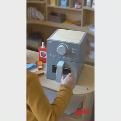 goki Airfryer aus Holz im Einsatz: Spiellebensmittel mit der Holzzange in die Schublade legen.
